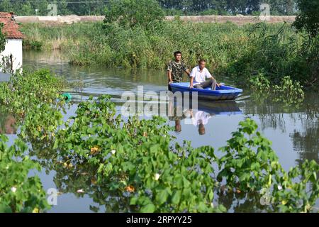 200718 -- JIUJIANG, 18. Juli 2020 -- Zhang Heng schickt seinen Vater per Boot nach Jiujiang, Ostchinesische Provinz Jiangxi, 17. Juli 2020. Zhang Heng, 27, war einst Mitglied der nationalen Flaggenwächter. Er entschied sich, in seine Heimatstadt zurückzukehren, um als Bauer zu arbeiten und sich nach Beendigung seines Militärdienstes um seine Eltern zu kümmern. Obwohl seine 60 Millionen Hektar großen Felder in diesem Jahr durch Überschwemmungen schwer beschädigt wurden, beteiligte sich Zhang Heng gemeinsam mit seinem Vater aktiv an den Hochwasserschutzbemühungen. Ich pflegte, die Ehre und würde meines Landes zu schützen, und jetzt bewache ich meine Eltern und meine Heimatstadt. Zhang sa Stockfoto