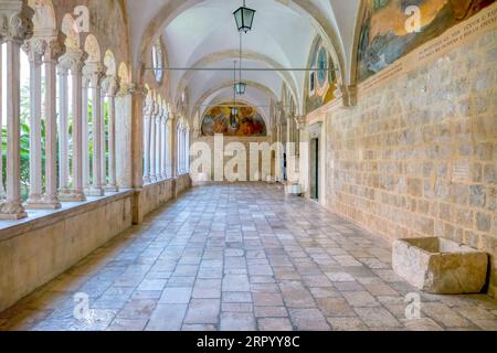 Dubrovnik, Kroatien - 3. Juni 2016. Ein Innenkorridor des mittelalterlichen Franziskanerklosters in der Altstadt, mit einsehbarem Innenhof. Stockfoto