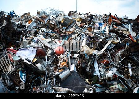 Großer Stapel verschiedener Abfallprodukte im Hof der Recyclinganlage Stockfoto