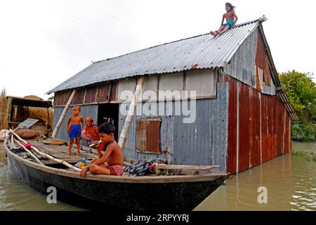 200720 -- FARIDPUR, 20. Juli 2020 Xinhua -- Bewohner werden in ihrem von Überschwemmungen betroffenen Haus in Faridpur, Bangladesch, 19. Juli 2020 gesehen. Überschwemmungen, ausgelöst durch starke saisonale Regenfälle und Wasseransammlungen aus Hügeln, haben sich in Teilen Bangladeschs, einschließlich des zentralen Viertels Faridpur, etwa 101 Kilometer von der Hauptstadt Dhaka entfernt, erneut verschlimmert. Xinhua BANGLADESH-FARIDPUR-FLOODPUBLICATIONXNOTXINXCHN Stockfoto