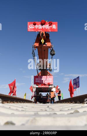 200721 -- RUOQIANG, 21. Juli 2020 -- Arbeiter legen Gleise auf der Golmud-Korla-Eisenbahnlinie nahe dem Altun-Gebirge in der nordwestchinesischen Autonomen Region Xinjiang Uygur, 21. Juli 2020. Die Verlegung von Gleisen für eine neue Strecke, die die autonome Region Xinjiang Uygur im Nordwesten Chinas mit der Provinz Qinghai und darüber hinaus verbindet, wurde am Dienstag abgeschlossen und ebnete den Weg für eine beschleunigte Entwicklung in der westlichen Region des Landes. Die 1.213,7 km lange Golmud-Korla-Bahn verbindet die Stadt Golmud in Qinghai mit der Stadt Korla in Xinjiang und soll noch in diesem Jahr in Betrieb genommen werden. CHINA-XINJIANG-GOLMUD Stockfoto