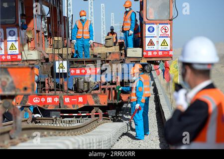 200721 -- RUOQIANG, 21. Juli 2020 -- Arbeiter legen die letzten Gleise auf der Golmud-Korla-Eisenbahnstrecke nahe dem Altun-Gebirge in der nordwestchinesischen autonomen Region Xinjiang Uygur, 21. Juli 2020. Die Verlegung von Gleisen für eine neue Strecke, die die autonome Region Xinjiang Uygur im Nordwesten Chinas mit der Provinz Qinghai und darüber hinaus verbindet, wurde am Dienstag abgeschlossen und ebnete den Weg für eine beschleunigte Entwicklung in der westlichen Region des Landes. Die 1.213,7 km lange Golmud-Korla-Bahn verbindet die Stadt Golmud in Qinghai mit der Stadt Korla in Xinjiang und soll noch in diesem Jahr in Betrieb genommen werden. CHINA-XINJI Stockfoto