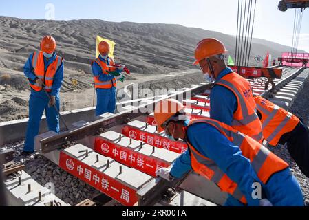 200721 -- RUOQIANG, 21. Juli 2020 -- Arbeiter legen die letzten Gleise auf der Golmud-Korla-Eisenbahnstrecke nahe dem Altun-Gebirge in der nordwestchinesischen autonomen Region Xinjiang Uygur, 21. Juli 2020. Die Verlegung von Gleisen für eine neue Strecke, die die autonome Region Xinjiang Uygur im Nordwesten Chinas mit der Provinz Qinghai und darüber hinaus verbindet, wurde am Dienstag abgeschlossen und ebnete den Weg für eine beschleunigte Entwicklung in der westlichen Region des Landes. Die 1.213,7 km lange Golmud-Korla-Bahn verbindet die Stadt Golmud in Qinghai mit der Stadt Korla in Xinjiang und soll noch in diesem Jahr in Betrieb genommen werden. CHINA-XINJI Stockfoto