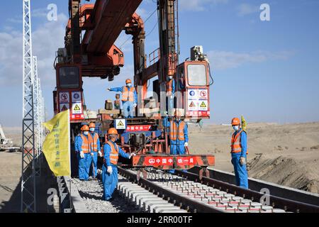 200721 -- RUOQIANG, 21. Juli 2020 -- Arbeiter legen die letzten Gleise auf der Golmud-Korla-Eisenbahnstrecke nahe dem Altun-Gebirge in der nordwestchinesischen autonomen Region Xinjiang Uygur, 21. Juli 2020. Die Verlegung von Gleisen für eine neue Strecke, die die autonome Region Xinjiang Uygur im Nordwesten Chinas mit der Provinz Qinghai und darüber hinaus verbindet, wurde am Dienstag abgeschlossen und ebnete den Weg für eine beschleunigte Entwicklung in der westlichen Region des Landes. Die 1.213,7 km lange Golmud-Korla-Bahn verbindet die Stadt Golmud in Qinghai mit der Stadt Korla in Xinjiang und soll noch in diesem Jahr in Betrieb genommen werden. CHINA-XINJI Stockfoto