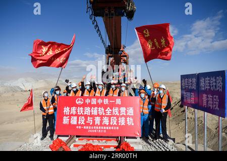 200721 -- RUOQIANG, 21. Juli 2020 -- Arbeiter feiern, nachdem sie die letzten Gleise auf der Golmud-Korla-Eisenbahnlinie in der Nähe des Altun-Gebirges in der nordwestchinesischen autonomen Region Xinjiang Uygur, 21. Juli 2020 gelegt haben. Die Verlegung von Gleisen für eine neue Strecke, die die autonome Region Xinjiang Uygur im Nordwesten Chinas mit der Provinz Qinghai und darüber hinaus verbindet, wurde am Dienstag abgeschlossen und ebnete den Weg für eine beschleunigte Entwicklung in der westlichen Region des Landes. Die 1.213,7 km lange Golmud-Korla-Bahn verbindet die Stadt Golmud in Qinghai mit der Stadt Korla in Xinjiang und soll später in Betrieb genommen werden Stockfoto