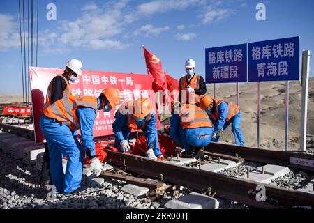 200721 -- RUOQIANG, 21. Juli 2020 -- Arbeiter legen die letzten Gleise auf der Golmud-Korla-Eisenbahnstrecke nahe dem Altun-Gebirge in der nordwestchinesischen autonomen Region Xinjiang Uygur, 21. Juli 2020. Die Verlegung von Gleisen für eine neue Strecke, die die autonome Region Xinjiang Uygur im Nordwesten Chinas mit der Provinz Qinghai und darüber hinaus verbindet, wurde am Dienstag abgeschlossen und ebnete den Weg für eine beschleunigte Entwicklung in der westlichen Region des Landes. Die 1.213,7 km lange Golmud-Korla-Bahn verbindet die Stadt Golmud in Qinghai mit der Stadt Korla in Xinjiang und soll noch in diesem Jahr in Betrieb genommen werden. CHINA-XINJI Stockfoto