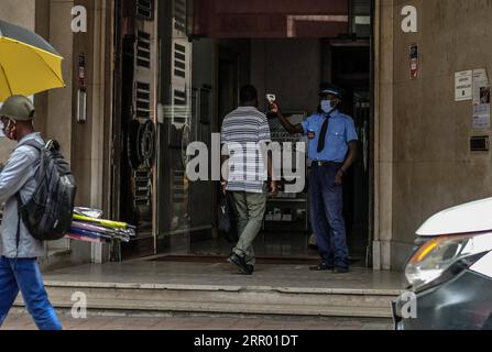 200722 -- DAKAR, 22. Juli 2020 Xinhua -- Ein Sicherheitsbeamter nimmt am 21. Juli 2020 die Körpertemperatur eines Kunden bei einer Bank in Zentral-Dakar, Senegal, auf. Foto von Eddy Peters/Xinhua SENEGAL-DAKAR-COVID-19-DAILY LIFE PUBLICATIONxNOTxINxCHN Stockfoto