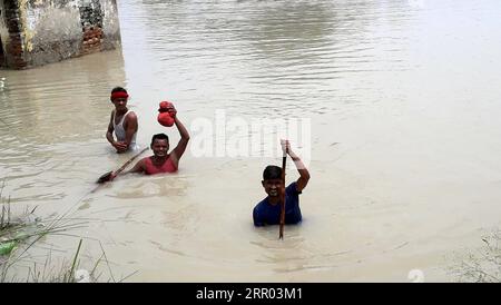 200726 -- BIHAR INDIA, 26. Juli 2020 -- Dorfbewohner waten am 26. Juli 2020 im Bezirk Muzaffarpur, Indiens östlichem Bundesstaat Bihar, durch Hochwasser. Mindestens 10 Menschen wurden getötet und fast 1,5 Millionen Menschen wurden von Überschwemmungen in 11 Bezirken im östlichen indischen Bundesstaat Bihar betroffen, sagte die staatliche Katastrophenverwaltung in einem Bulletin am Sonntag. STR/Xinhua INDIA-BIHAR-FLOODS ParthaxSarkar PUBLICATIONxNOTxINxCHN Stockfoto