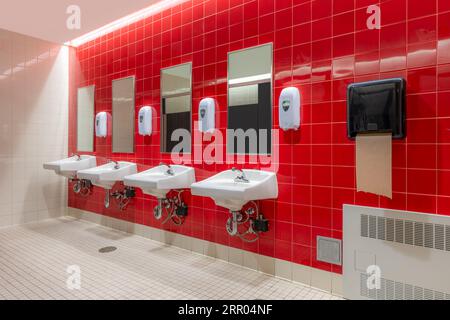 Öffentliche Toilette mit roten Fliesen und vier, Toiletten, Waschbecken Stockfoto