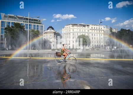 200729 -- PEKING, 29. Juli 2020 -- Ein Radfahrer passiert einen Wasserstrahl am Schwarzenbergplatz in Wien, 28. Juli 2020. Die höchste Temperatur in Wien erreichte am Dienstag 37,2 Grad Celsius. XINHUA-FOTOS DES TAGES GuoxChen PUBLICATIONxNOTxINxCHN Stockfoto