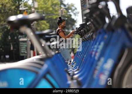 200730 -- NEW YORK, 30. Juli 2020 -- Eine Frau wählt ein Leihfahrrad in New York, USA, 29. Juli 2020. COVID-19-Todesfälle in den USA haben die 150.000-Marke überschritten und erreichen am Mittwoch, 1935 GMT, um 15:35 Uhr Ortszeit 150.034, so das Center for Systems Science and Engineering an der Johns Hopkins University. U.S.-NEW YORK-COVID-19-CASES WangxYing PUBLICATIONxNOTxINxCHN Stockfoto