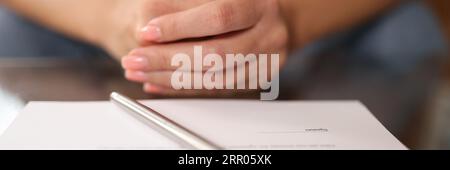 Frau sitzt am Tisch, Dokumente zur Unterschrift Stockfoto