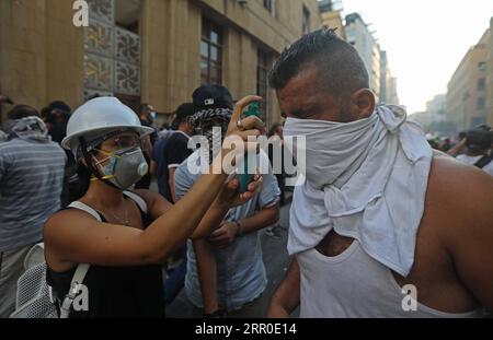 200810 -- BEIRUT, 10. August 2020 -- Eine Frau hilft einem Demonstranten, der am 10. August 2020 in der Innenstadt von Beirut, Libanon, von Tränengas getroffen wurde. Beirut wurde letzte Woche von zwei gewaltigen Explosionen erschüttert, bei denen mindestens 158 Menschen ums Leben kamen und 6.000 weitere verletzt wurden. Tausende gingen auf die Straßen in der Innenstadt von Beirut, um die Überarbeitung des politischen Systems zu fordern. LIBANON-BEIRUT-PROTEST-CLASH LixLiangyong PUBLICATIONxNOTxINxCHN Stockfoto