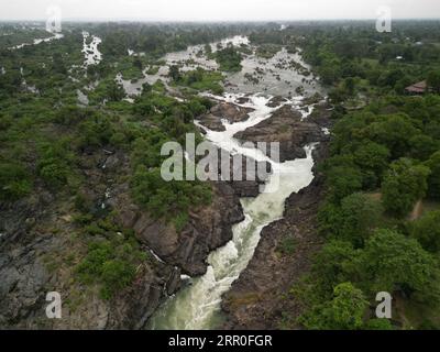 Ein Blick aus der Luft auf einen Wasserfall, der einen Berg in Laos hinunterfließt Stockfoto