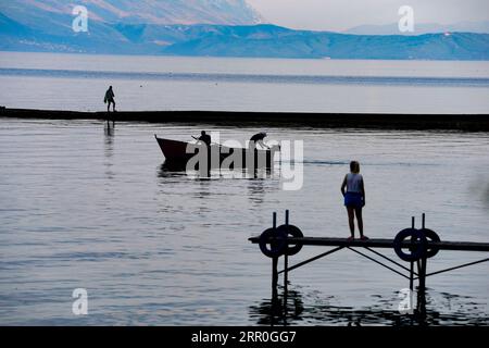 200814 -- SKOPJE, 14. August 2020 Xinhua -- die Menschen genießen ihre Zeit an einem Dock am Ufer des Ohrid-Sees in Struga, Nordmazedonien, am 13. August 2020. Die Zahl der Touristen in Nordmazedonien ging im Juni dieses Jahres um 95,6 Prozent im Vergleich zum Vorjahr zurück, während die Nächte, die von ihnen verbracht wurden, um 94,6 Prozent zurückgingen, berichtete das staatliche Statistische Amt der SSO am Mittwoch. Laut SSO-Daten wurden im Juni insgesamt 5.210 Touristen registriert, und die Zahl der Übernachtungen, die Touristen im Land verbrachten, betrug 14.179. Foto von Tomislav Georgiev/Xinhua NORDMAZEDONIEN-SKOPJE-COVID-19-TOURISTEN-RÜCKGANG PUBLICATIONxNOTxI Stockfoto