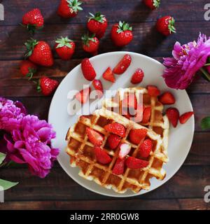 Waffeln mit Erdbeeren und Pfingstrosen Stockfoto