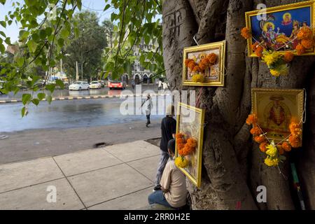 Religiöse Hinduikonen, die am 29. August 2023 in Mumbai, Indien, an einem Baum im Bezirk Kala Ghoda gehängt wurden, in dem sich mehrere der denkmalgeschützten Gebäude der Stadt befinden Stockfoto