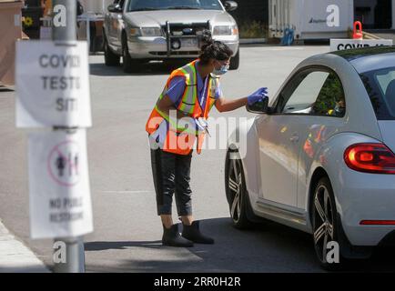 200814 -- VANCOUVER, 14. August 2020 -- Ein Arbeiter zeigt einem Fahrer am Eingang zu einer COVID-19-Testeinrichtung in Vancouver, British Columbia, Kanada, am 14. August 2020 die Richtung des Line-up-Bereichs. Die COVID-19-Kurve von British Columbia steigt jetzt schneller als der erste Ausbruch im März, und neue provinzielle Modellierungen zeigen, dass B.C. bis September eine zweite Welle sehen könnte, die größer ist als die erste. Foto von /Xinhua CANADA-VANCOUVER-COVID-19-TEST LiangxSen PUBLICATIONxNOTxINxCHN Stockfoto