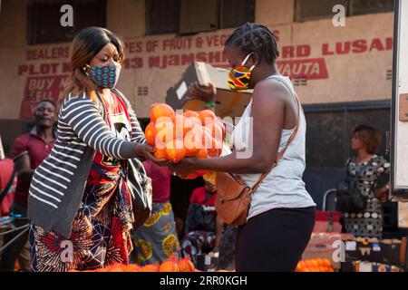 200818 -- LUSAKA, 18. August 2020 -- Eine Frau, die Eine Gesichtsmaske trägt, kauft am 18. August 2020 Orangen auf einem Markt in Lusaka, der Hauptstadt Sambias. Die bestätigten COVID-19-Fälle Sambias sind weiter gestiegen, wobei die Gesamtzahl der Fälle nahe der Marke von 10.000 liegt. Nach den neuesten Zahlen, die vom gesundheitsministerium am Dienstag veröffentlicht wurden, hat das Land 9.981 bestätigte Fälle nach 142 neuen Fällen gemeldet, die in den letzten 24 Stunden von 794 durchgeführten Tests aufgezeichnet wurden. Foto von /Xinhua ZAMBIA-LUSAKA-COVID-19-CASES MartinxMbangweta PUBLICATIONxNOTxINxCHN Stockfoto