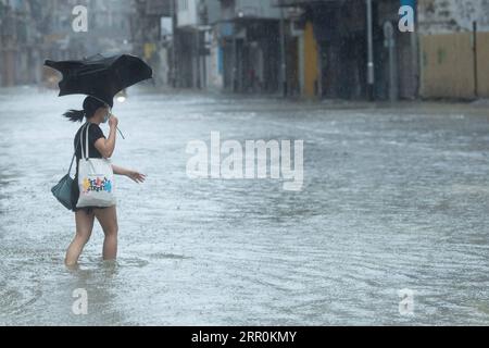 200819 -- MACAO, 19. August 2020 Xinhua -- Eine Frau geht auf einer überfluteten Straße in Macau, Südchina, 19. August 2020. Die Sonderverwaltungsregion Macau in China hat ihr Taifun-Signal von der höchsten Stufe 10 auf die Nummer 8 am Mittwoch um 7:30 Uhr Ortszeit herabgestuft, aber die tief gelegenen Gebiete in der Nähe der Küste wurden überflutet, da der Taifun Higos am Morgen in der Nachbarstadt Zhuhai landete. Das Macao Meteorological and Geophysical Bureau hatte sein Taifun-Signal am Mittwoch um 5:00 Uhr Ortszeit auf Platz 10 erhöht, bevor es später auf Platz 8 herabgestuft wurde. Die rote Sturmwarnung W Stockfoto