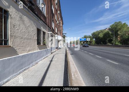 Eine Straße außerhalb der Stadt neben den flachen Wohnhäusern Stockfoto