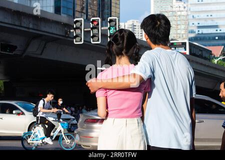 200826 -- PEKING, 26. August 2020 -- Ein Paar beobachtet die herzförmige Ampel an einer Handelsstraße in Changsha, Provinz Hunan in Zentralchina, 25. August 2020. Die Verkehrspolizei in Changsha änderte vorübergehend die Ampeln in Form von Herzen entlang einer geschäftigen Handelsstraße in der Stadt, um die traditionelle chinesische Kultur zu fördern und die Öffentlichkeit zu bitten, die Verkehrsregeln am Qixi Festival oder traditionellen chinesischen Valentinstag einzuhalten. XINHUA FOTOS DES TAGES ChenxSihan PUBLICATIONxNOTxINxCHN Stockfoto