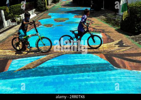 200826 -- JAKARTA, 26. August 2020 -- Kinder fahren mit dem Fahrrad auf einem Fußgängerweg mit dreidimensionalen Gemälden in Jakarta, Indonesien, 26. August 2020. Foto von /Xinhua INDONESIA-JAKARTA-3D-MALEREI DasrilxRoszandi PUBLICATIONxNOTxINxCHN Stockfoto