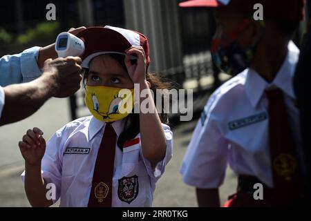 200826 -- JAKARTA, 26. August 2020 -- eine Grundschülerin mit Gesichtsmaske lässt ihre Temperatur überprüfen, bevor sie einen Masern-Röteln-MR-Impfstoff während des COVID-19-Ausbruchs in Jakarta, Indonesien, 26. August 2020 erhält. Masern-Röteln-MRT-Impfstoffe werden Jugendlichen als Teil des Programms der indonesischen Regierung verabreicht, um Schulkindern eine angemessene Immunisierung anzubieten. INDONESIEN-JAKARTA-MASERN-RÖTELN-IMMUNISIERUNG AGUNGXKUNCAHYAXB. PUBLICATIONxNOTxINxCHN Stockfoto