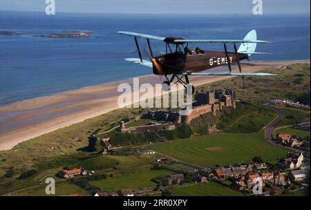 Die Tiger Moth aus dem Zweiten Weltkrieg führt über Bamburgh Castle in Northumberland in den Himmel. Die DH82A Tiger Moth wurde 1940 gebaut und gehört Darren Davis und Dave Burns von Tiger Flights, einem unabhängigen Unternehmen mit Sitz auf dem Eshott Airfield. Je nach Wetterlage wird G-EMSY das ganze Jahr über fliegen, was Luftfahrtfans das unvergleichliche Erlebnis des Cockpitflugs mit offenem Cockpit und einen einzigartigen Blick auf die Landschaft von Northumberland und ikonische Wahrzeichen bietet. Bilddatum: Dienstag, 5. September 2023. Stockfoto