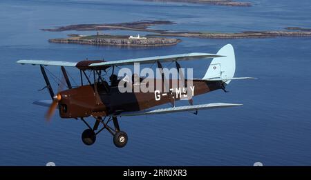 Die Tiger Moth aus dem Zweiten Weltkrieg bringt Sie über die Farne-Inseln in den Himmel. Die DH82A Tiger Moth wurde 1940 gebaut und gehört Darren Davis und Dave Burns von Tiger Flights, einem unabhängigen Unternehmen mit Sitz auf dem Eshott Airfield. Je nach Wetterlage wird G-EMSY das ganze Jahr über fliegen, was Luftfahrtfans das unvergleichliche Erlebnis des Cockpitflugs mit offenem Cockpit und einen einzigartigen Blick auf die Landschaft von Northumberland und ikonische Wahrzeichen bietet. Bilddatum: Dienstag, 5. September 2023. Stockfoto