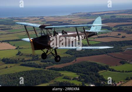 Die Tiger Moth aus dem Zweiten Weltkrieg bringt Sie in den Himmel über Northumberland. Die DH82A Tiger Moth wurde 1940 gebaut und gehört Darren Davis und Dave Burns von Tiger Flights, einem unabhängigen Unternehmen mit Sitz auf dem Eshott Airfield. Je nach Wetterlage wird G-EMSY das ganze Jahr über fliegen, was Luftfahrtfans das unvergleichliche Erlebnis des Cockpitflugs mit offenem Cockpit und einen einzigartigen Blick auf die Landschaft von Northumberland und ikonische Wahrzeichen bietet. Bilddatum: Dienstag, 5. September 2023. Stockfoto