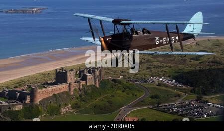 Die Tiger Moth aus dem Zweiten Weltkrieg führt über Bamburgh Castle in Northumberland in den Himmel. Die DH82A Tiger Moth wurde 1940 gebaut und gehört Darren Davis und Dave Burns von Tiger Flights, einem unabhängigen Unternehmen mit Sitz auf dem Eshott Airfield. Je nach Wetterlage wird G-EMSY das ganze Jahr über fliegen, was Luftfahrtfans das unvergleichliche Erlebnis des Cockpitflugs mit offenem Cockpit und einen einzigartigen Blick auf die Landschaft von Northumberland und ikonische Wahrzeichen bietet. Bilddatum: Dienstag, 5. September 2023. Stockfoto