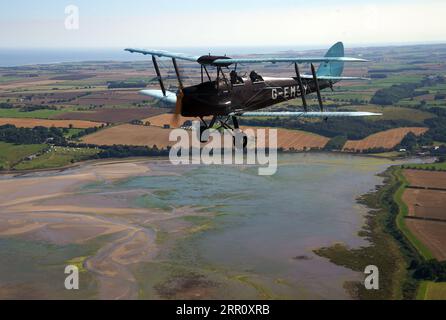 Die Tiger Moth aus dem Zweiten Weltkrieg bringt Sie in den Himmel über Northumberland. Die DH82A Tiger Moth wurde 1940 gebaut und gehört Darren Davis und Dave Burns von Tiger Flights, einem unabhängigen Unternehmen mit Sitz auf dem Eshott Airfield. Je nach Wetterlage wird G-EMSY das ganze Jahr über fliegen, was Luftfahrtfans das unvergleichliche Erlebnis des Cockpitflugs mit offenem Cockpit und einen einzigartigen Blick auf die Landschaft von Northumberland und ikonische Wahrzeichen bietet. Bilddatum: Dienstag, 5. September 2023. Stockfoto