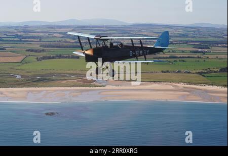 Die Tiger Moth aus dem Zweiten Weltkrieg bringt Sie in den Himmel über Northumberland. Die DH82A Tiger Moth wurde 1940 gebaut und gehört Darren Davis und Dave Burns von Tiger Flights, einem unabhängigen Unternehmen mit Sitz auf dem Eshott Airfield. Je nach Wetterlage wird G-EMSY das ganze Jahr über fliegen, was Luftfahrtfans das unvergleichliche Erlebnis des Cockpitflugs mit offenem Cockpit und einen einzigartigen Blick auf die Landschaft von Northumberland und ikonische Wahrzeichen bietet. Bilddatum: Dienstag, 5. September 2023. Stockfoto