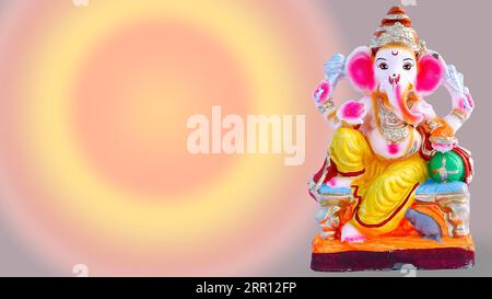 Lord Ganesha Idol mit Rosenblüten, weißen Blumen und Blättern auf buntem Hintergrund, Ganesh pooja Stockfoto