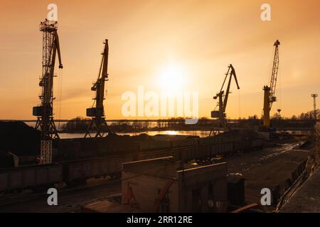 Kohleterminal in Vyborg. Silhouetten von Portalkränen am Abend Stockfoto