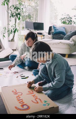 Mutter und Sohn zeichnen zu Hause im Wohnzimmer Stockfoto