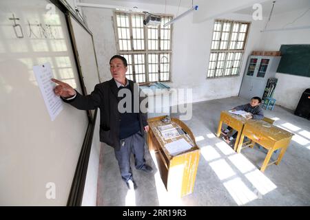 200910 -- NANNING, 10. September 2020 -- Lehrer Liu Xianyue gibt seinem Schüler Zhou Xiong in der Gemeinde Longyan in der südchinesischen autonomen Region Guangxi Zhuang am 4. Dezember 2019 eine Lektion. Tausende von Lehrern bleiben in den Bergregionen Guangxis, einem der wichtigsten Schlachtfelder der Armutsbekämpfung im Land, an ihrem Posten. CHINA-GUANGXI-BERGREGIONEN-LEHRER CN LUXBOAN PUBLICATIONXNOTXINXCHN Stockfoto