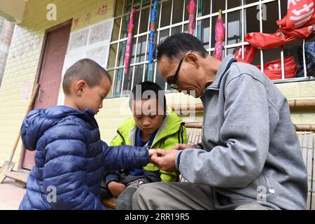 200910 -- NANNING, 10. September 2020 -- Lehrer Zhou Hongjun schneidet Nägel für einen Schüler während der Klassenpause an einer Grundschule in Xinhe Village, Rongshui Miao Autonomous County der autonomen Region Guangxi Zhuang in Südchina, 28. Mai 2019. Tausende von Lehrern bleiben in den Bergregionen Guangxis, einem der wichtigsten Schlachtfelder der Armutsbekämpfung im Land, an ihrem Posten. CHINA-GUANGXI-BERGREGIONEN-LEHRER CN LUXBOAN PUBLICATIONXNOTXINXCHN Stockfoto