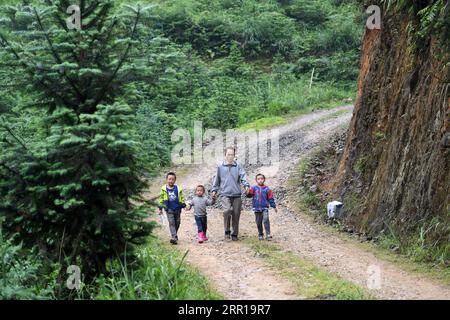 200910 -- NANNING, 10. September 2020 -- Lehrer Zhou Hongjun führt Schüler nach dem Mittagessen in das Dorf Xinhe im autonomen Kreis Rongshui Miao, südchinesische Autonome Region Guangxi Zhuang, 28. Mai 2019 zurück zur Schule. Tausende von Lehrern bleiben in den Bergregionen Guangxis, einem der wichtigsten Schlachtfelder der Armutsbekämpfung im Land, an ihrem Posten. CHINA-GUANGXI-BERGREGIONEN-LEHRER CN LUXBOAN PUBLICATIONXNOTXINXCHN Stockfoto