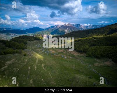 Eine Luftaufnahme eines Flusses, der durch grüne Berge fließt Stockfoto