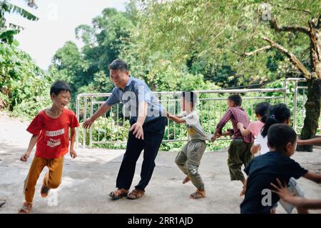 200911 -- PEKING, 11. September 2020 -- Lehrer Jiao Shengding spielt Spiel mit Schülern in der Gemeinde Aidian in der autonomen Region Guangxi Zhuang in Südchina, 22. Juni 2020. Tausende von Lehrern bleiben in den Bergregionen Guangxis, einem der wichtigsten Schlachtfelder der Armutsbekämpfung im Land, an ihrem Posten. XINHUA FOTOS DES TAGES CuixBowen PUBLICATIONxNOTxINxCHN Stockfoto