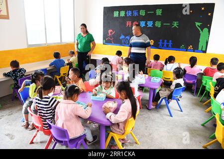 200913 -- RONGJIANG, 13. September 2020 -- Gun Luquan und Pan Mingzhen begleiten Schüler während der Mittagspause in der Miaoben Primary School in Zhongcheng Township, Rongjiang County, Südwestchinesische Provinz Guizhou, 9. September 2020. Gun Luquan und seine Frau Pan Mingzhen sind ein Lehrerpaar, das sich mehr als 20 Jahre lang ländlichen Schülern an der Miaoben Primary School im bergigen Rongjiang County widmete. Da die Schule nur noch zwei Lehrkräfte hat, haben Gun und Pan ihre ursprüngliche Verfolgung nie aufgegeben und ihr Bestes gegeben, um den Schülern eine angemessene Schulerfahrung zu bieten. CHINA- Stockfoto