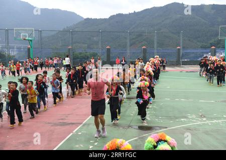 200915 -- LINGYUN, 15. September 2020 -- Shen Yequan C, Front und Studenten laufen auf dem Basketballfeld während einer Klassenpause in der Lanjin Primary School in Sicheng Township im Lingyun County, südchinesische Autonome Region Guangxi Zhuang, 10. September 2020. Shen, 28, ist der einzige Lehrer der Dorfschule. 2018 wurde er nach seinem Bachelor-Abschluss in Sport zum Sportlehrer in der Schule ernannt. Aufgrund unserer unerbittlichen Bemühungen haben Kinder einen starken Wunsch nach körperlichen Aktivitäten. Ich werde hier bleiben, um Kindern auf dem Lande dabei zu helfen, die Gewohnheit zu pflegen, an mir teilzunehmen Stockfoto