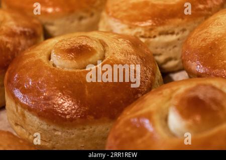 Nahaufnahme von frisch gebackenem, köstlichem, heißem Rundbrot mit knuspriger Kruste auf dem Tisch in der Bäckerei Stockfoto