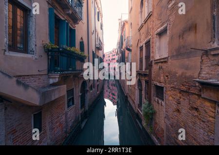 Fantastische Landschaft mit alten Wohngebäuden und schmalem Kanal gegen den Himmel an sonnigen Tagen in Venedig Stockfoto