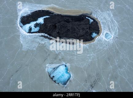 Blick aus der Vogelperspektive auf das gesprungene Eisgelände des gefrorenen Wassers, das die Landschaft mit den grünen Bäumen der Insel Madeira Portugal bei sonnigem Tageslicht umgibt Stockfoto