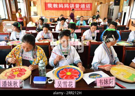 200928 -- RONGSHUI, 28. September 2020 -- die Bewohner von Miao, die ein Mandarin-Trainingsprogramm besuchen, lernen am Rande ihrer Sprachkurse in Wuying Village, das an der Grenze zwischen der südchinesischen autonomen Region Guangxi Zhuang und der südwestchinesischen Provinz Guizhou liegt, am 9. September 2020 Fanzeichnungen. Wuying liegt tief in den Bergen an der Grenze zwischen der autonomen Region Guangxi Zhuang und der Provinz Guizhou und ist ein abgelegenes Dorf, das von der ethnischen Gruppe der Miao bewohnt wird, in dem Frauen über 40 kaum jemals eine Schule besucht haben. In ihrer Kindheit waren sie mit Hütkatzen beschäftigt Stockfoto