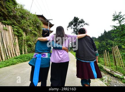 200928 -- RONGSHUI, 28. September 2020 -- Student Pan Muzhi 2. L begleitet die Miao-Dorfbewohner Liang Yingmi 1. L und Liang Zuying 1. R auf ihrem Weg zu einem Mandarin-Trainingsprogramm im Dorf Wuying, das am 6. Juni 2020 an der Grenze zwischen der südchinesischen autonomen Region Guangxi Zhuang und der südwestlichen chinesischen Provinz Guizhou liegt. Wuying liegt tief in den Bergen an der Grenze zwischen der autonomen Region Guangxi Zhuang und der Provinz Guizhou und ist ein abgelegenes Dorf, das von der ethnischen Gruppe der Miao bewohnt wird, in dem Frauen über 40 kaum jemals eine Schule besucht haben. In ihrer Kindheit waren sie sehr jung Stockfoto