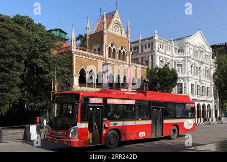 Die Autos passieren die David Sassoon Library und das Army & Navy Building im Kala Ghoda District, in dem sich mehrere der historischen Gebäude der Stadt in Mumbai, Indien, befinden. Stockfoto